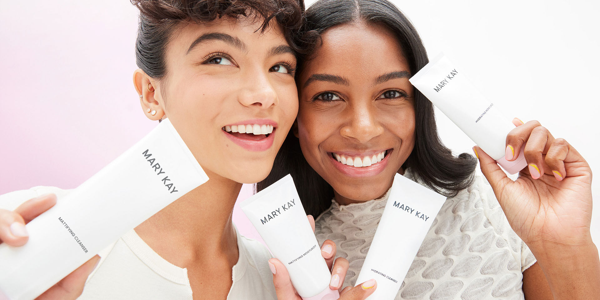 Dos modelos sosteniendo productos de la rutina de cuidado de la piel Mary Kay&reg; y sonriendo